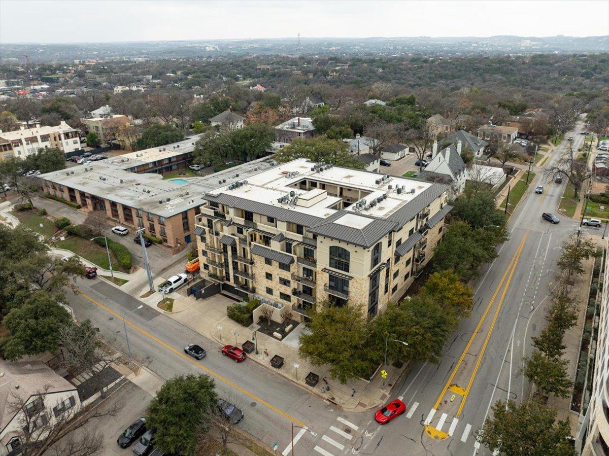 Aerial view of a dense residential neighborhood with apartment buildings, houses, and tree-lined streets.